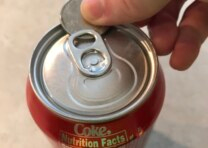 Yooz a coin, possibly a quarter, to open a pop can