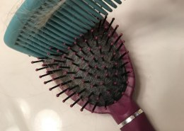 Yooz a comb to get hair out of a brush